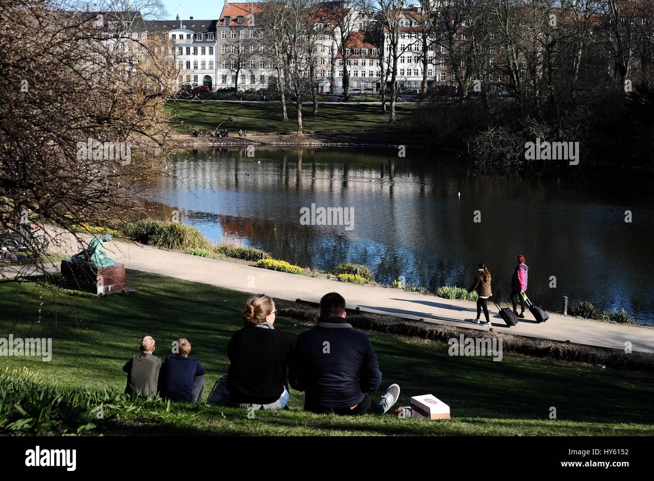 Visitors enjoying a strong spring sun at Ørstedsparken, a city centre park in Copenhagen, Denmark Stock Photo