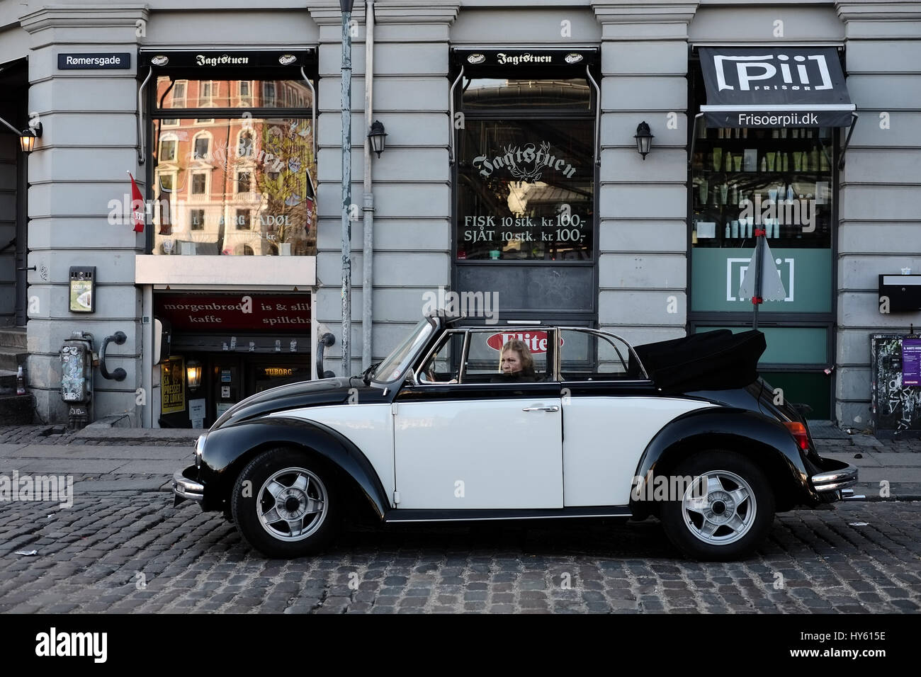 Person sitting in classic black and white Volkswagen Beetle Convertible near Torvehallerne, Copenhagen, Denmark Stock Photo