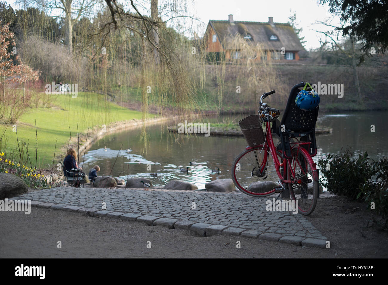 Mother and child playing by peaceful lake, Frederiksberg Gardens, Copenhagen, Denmark Stock Photo