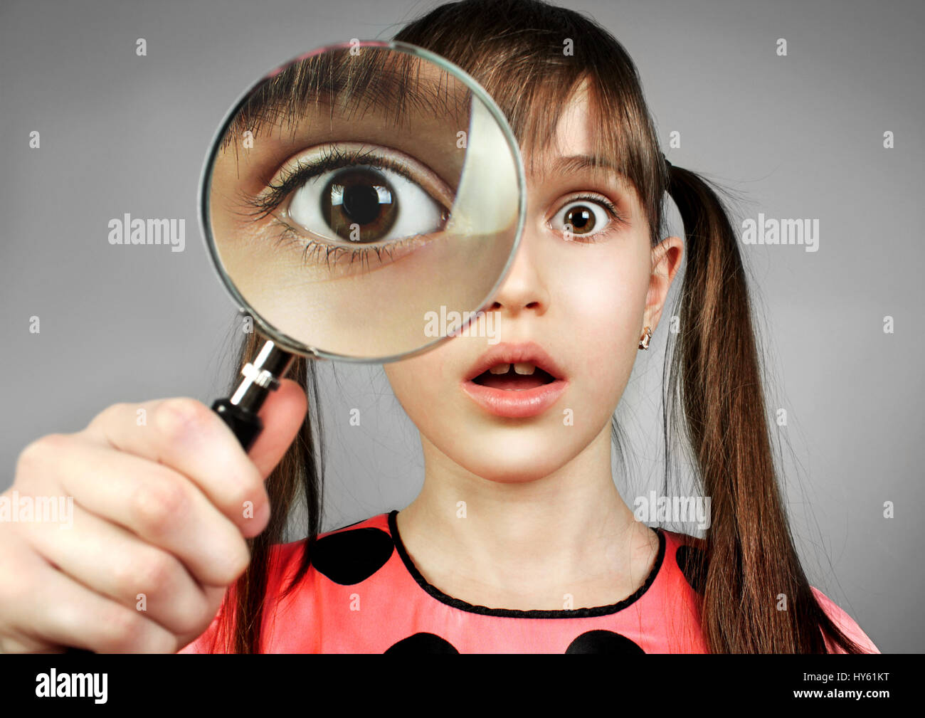 surprised girl, searching  with magnifying glass Stock Photo