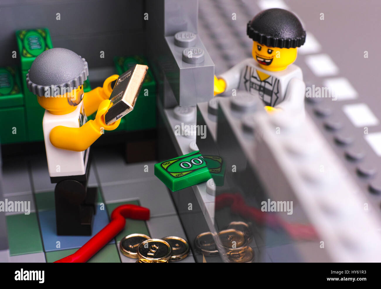 Tambov, Russian Federation - January 08, 2017 Lego bank burglary. Two robbers broke bank wall and take out money and gold. Studio shot. Stock Photo