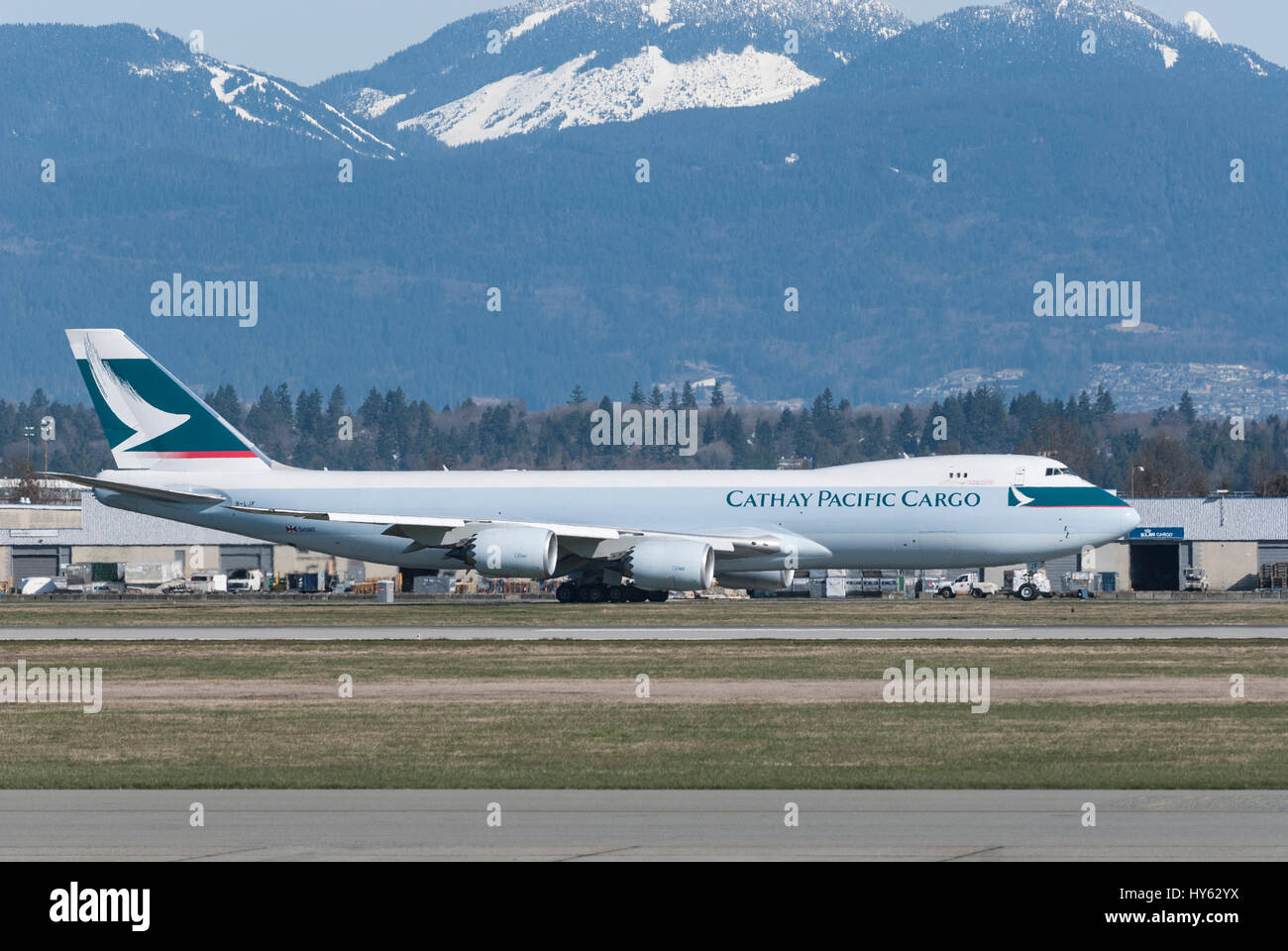 Cathay Pacific Wide Body Boeing 747 cargo plane taxing down runway at Vancouver International airport. Stock Photo