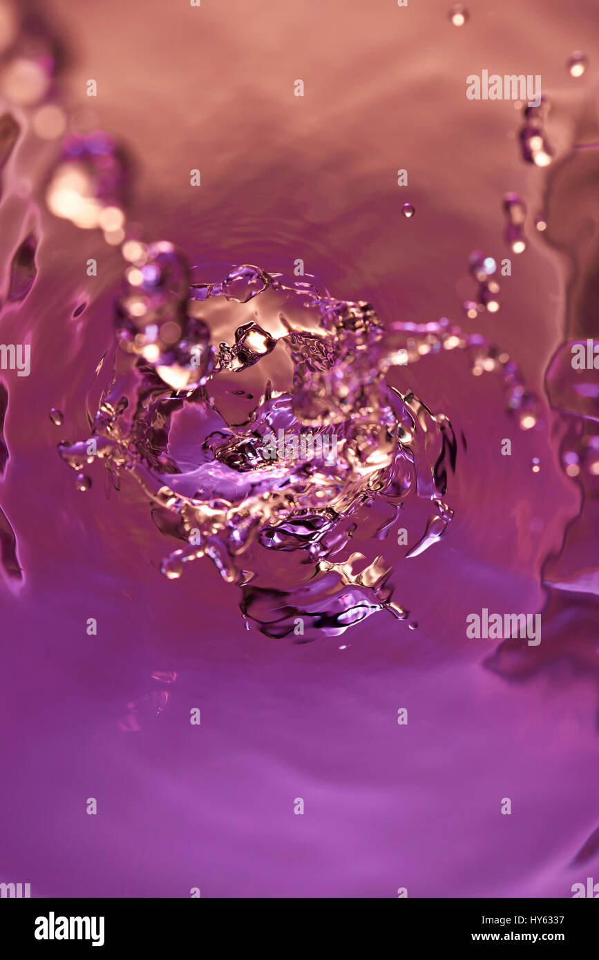 Big water splash above view. Purple liquid abstract wallpaper background Stock Photo