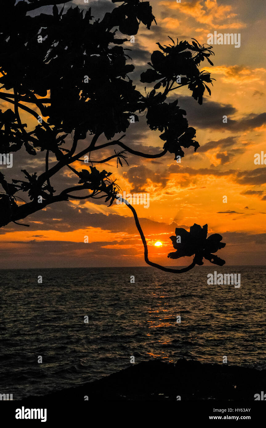 Setting sun over the ocean in the tropical waters of Kona, Hawaii Stock Photo