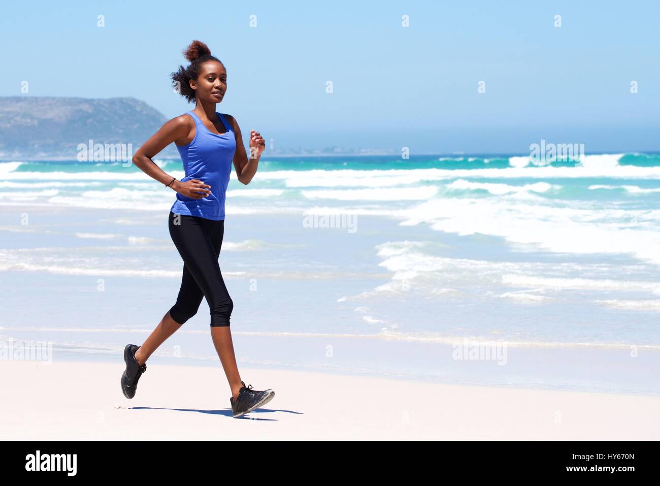 Full body portrait of healthy young female running on the beach Stock ...