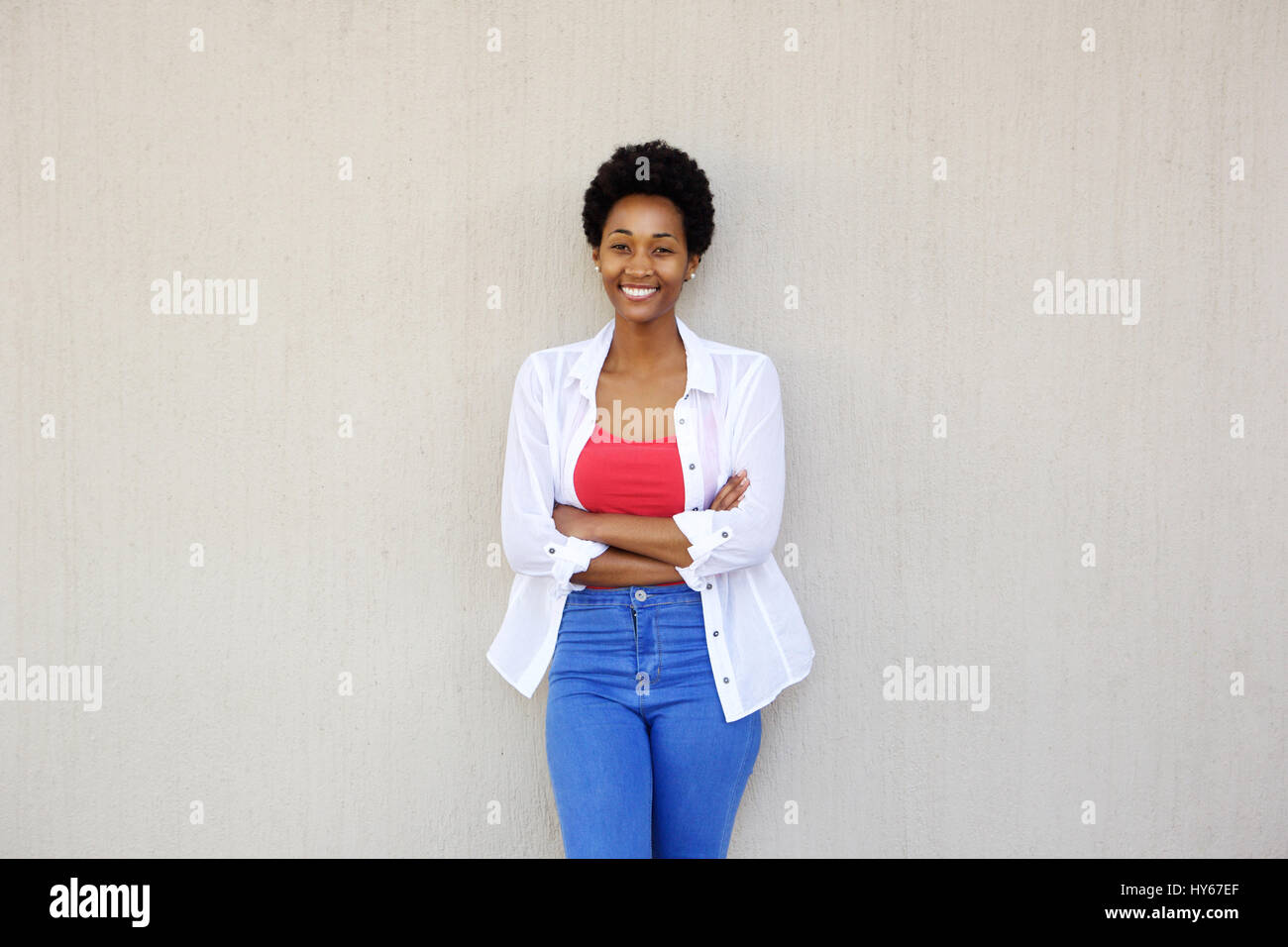 Portrait of a confident young african woman with arms crossed standing ...