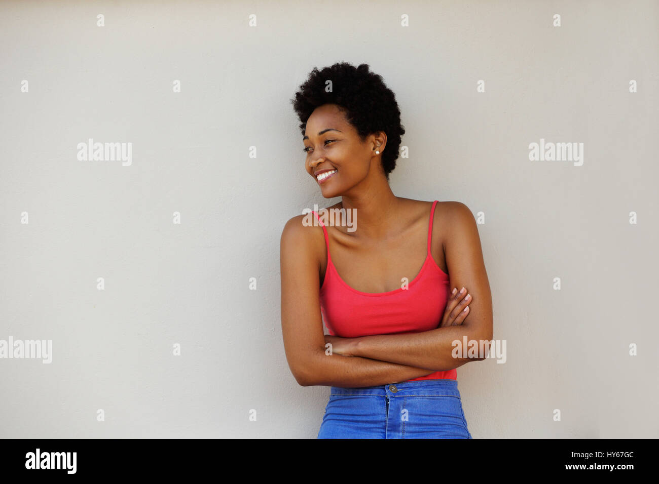 Portrait of an attractive young african woman standing with her arms ...