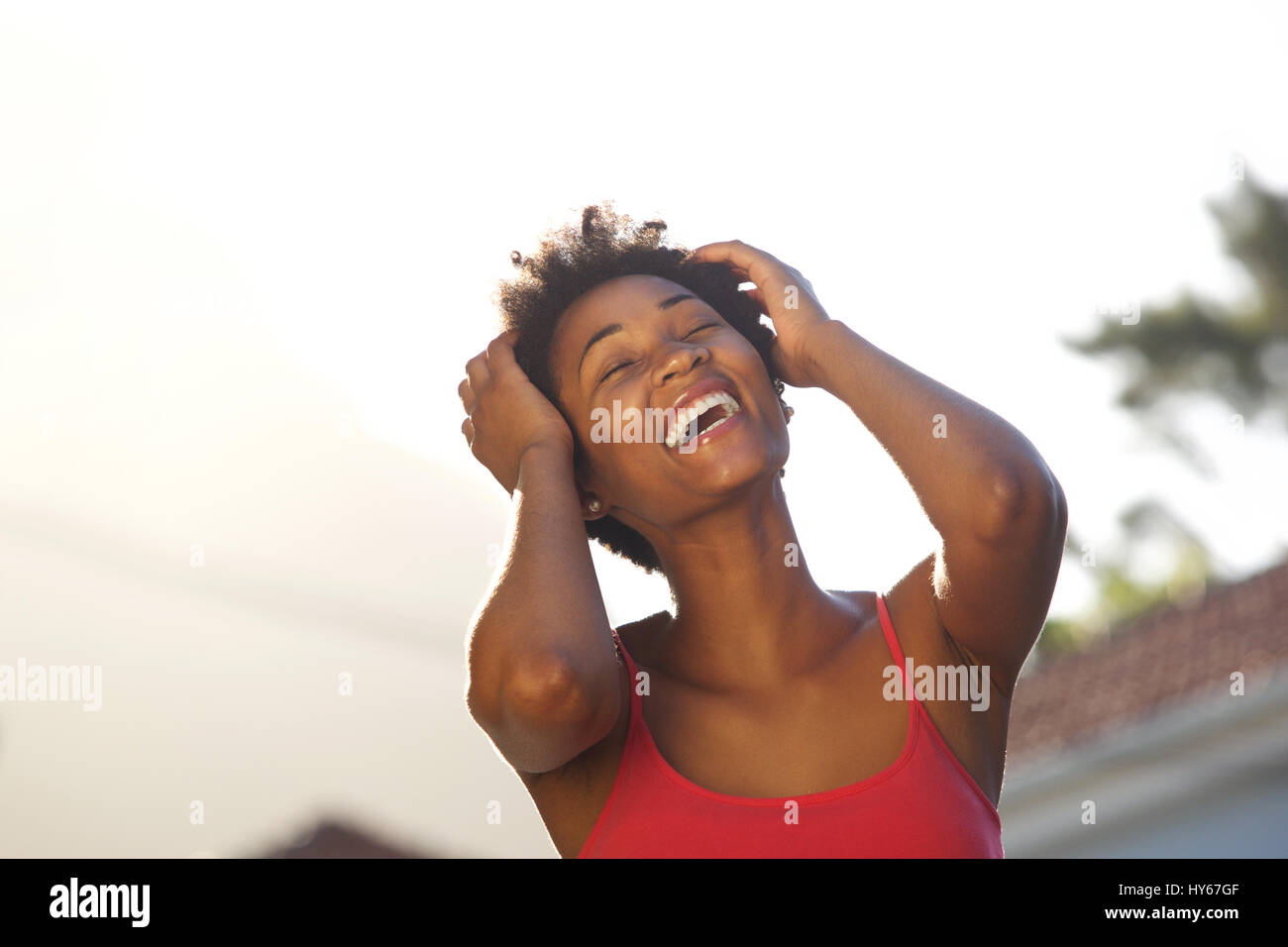 Close up portrait of cheerful young african woman laughing outdoors ...