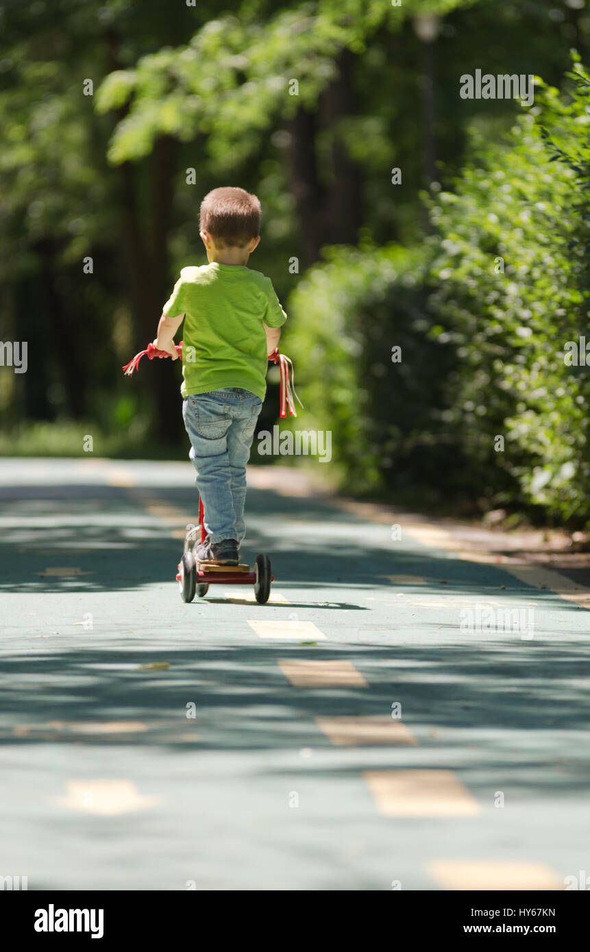 Kid  with a push scooter rolling on the line Stock Photo
