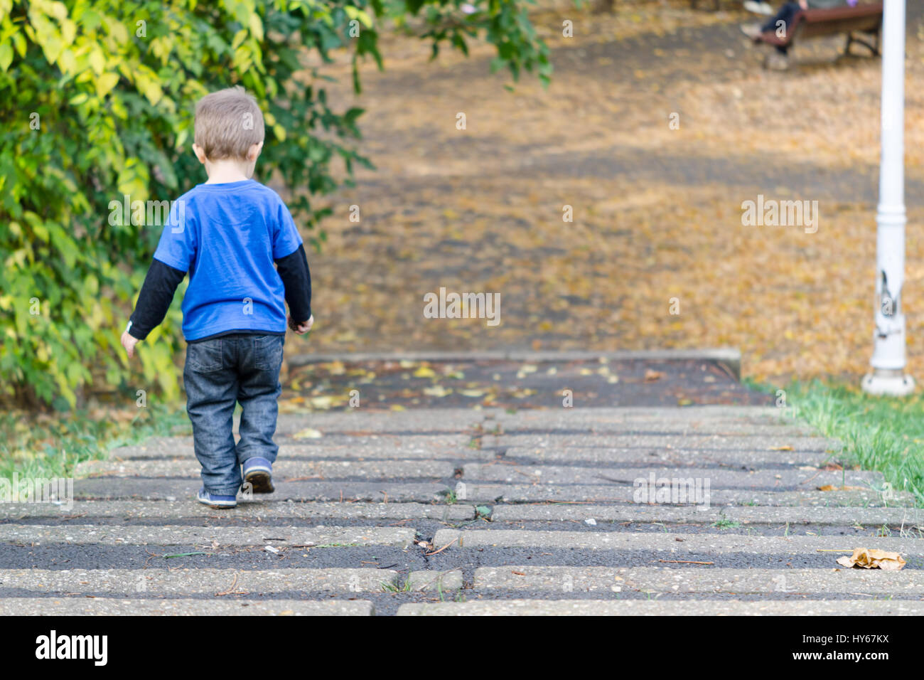 Beautiful kid climbs down the stairs Stock Photo