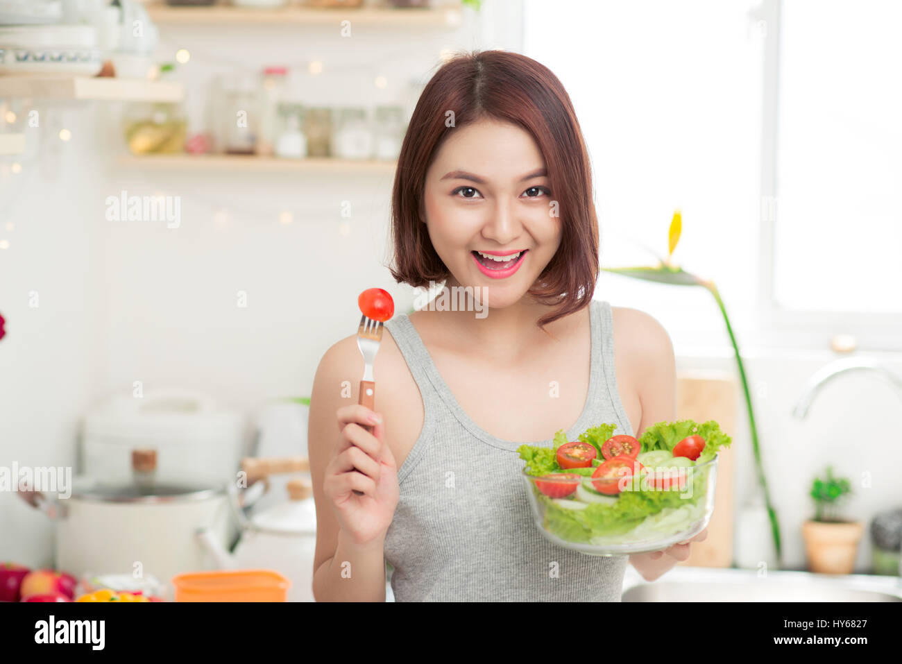 Beautiful young asian girl eating salad. smiling happy girl eating healthy  food Stock Photo - Alamy