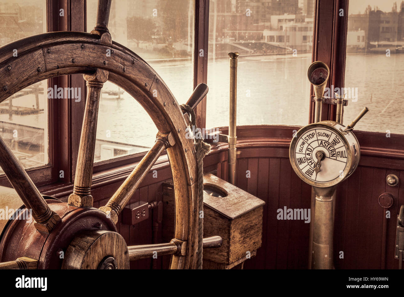 steering wheel and engine controls (telegraph) on a vintage ship bridge, retro sepia toning Stock Photo