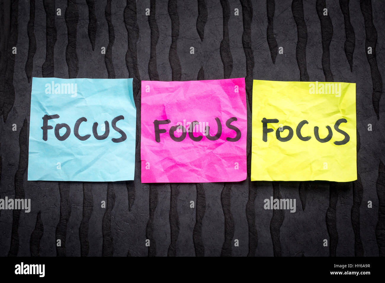 Focus concept - handwriting on sticky notes against black lokta paper Stock Photo