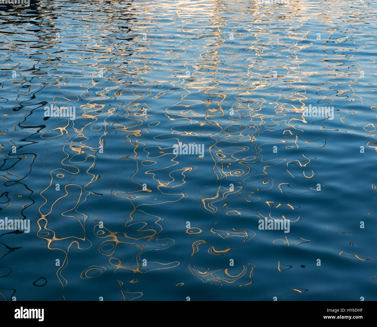 moving reflections of sailing boats in the blue water of Port Vell, Barcelona, Catalonia, Spain Stock Photo