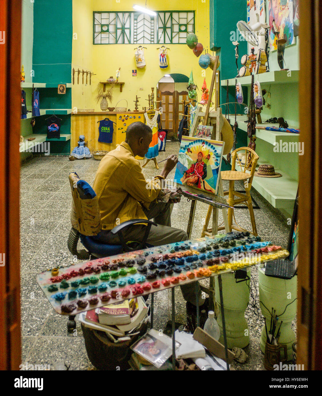 A Cuban artist painting in his gallery in old Havana, Cuba Stock Photo