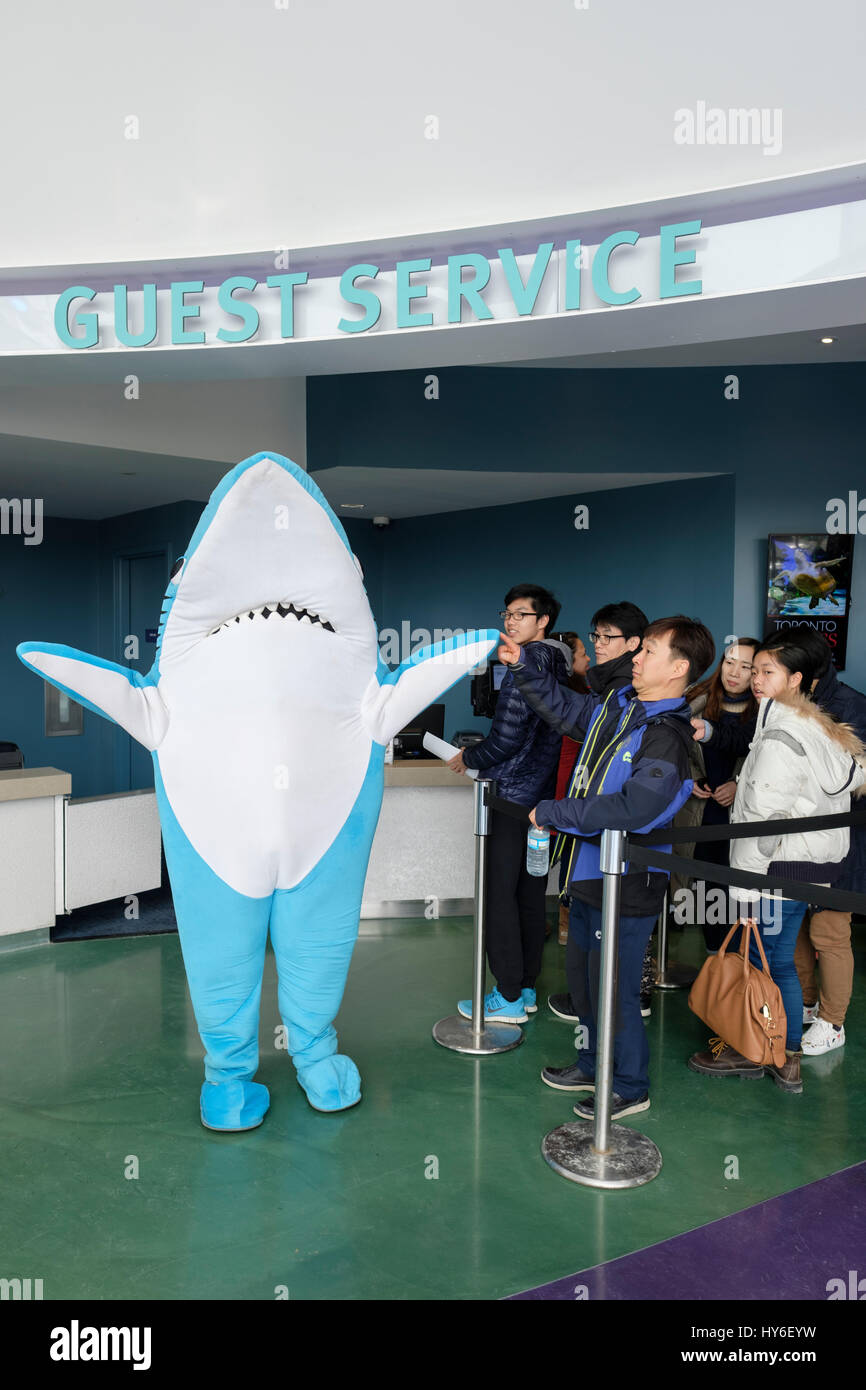 Ripley's Aquarium of Canada shark mascot greeting visitors at the guest