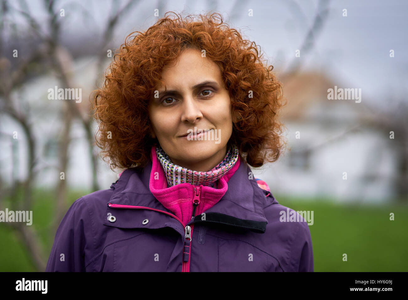 Curly redhead woman outdoor in the countryside, candid portrait Stock ...