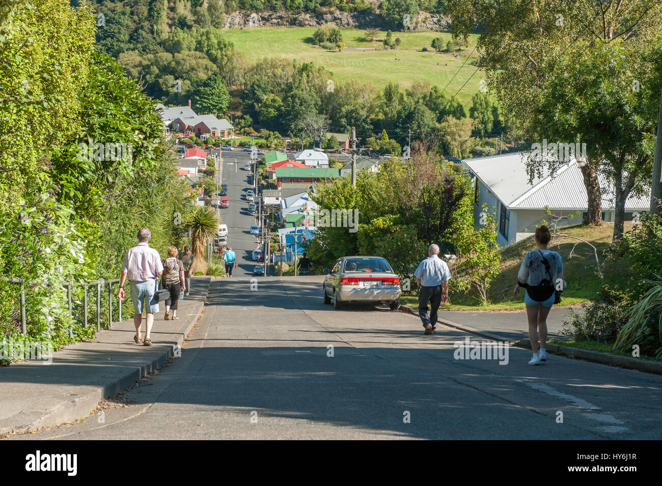 Tourists walk at Baldwin street on February 17, 2012 in Dunedin. This is regarded as the steepest residential street in the world. Stock Photo