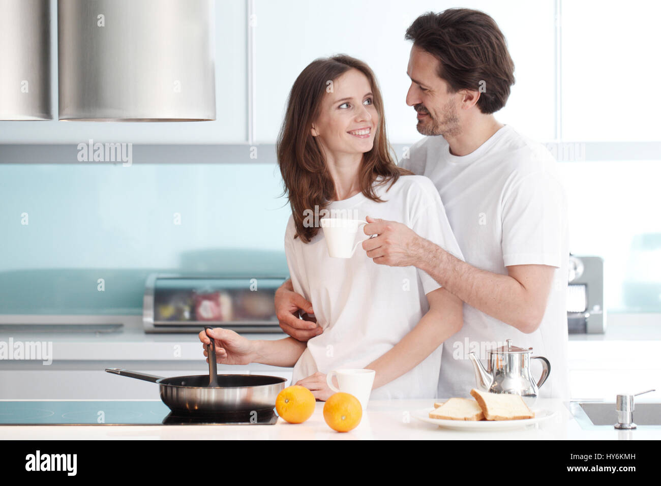 Happy Couple Cooking Breakfast Together In The Kitchen Stock Photo - Alamy