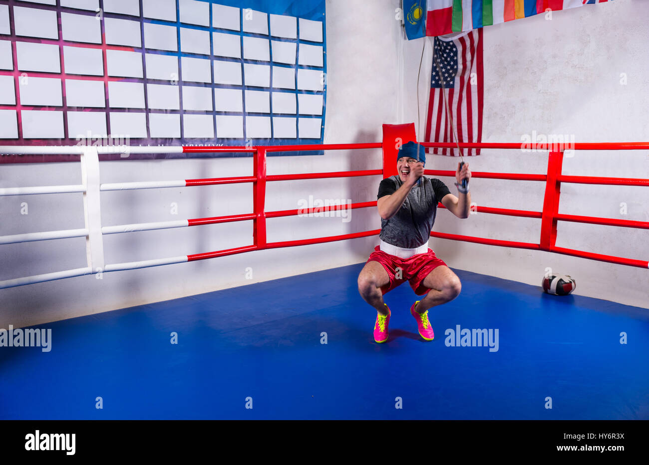 Male boxer skipping rope in a regular boxing ring surrounded by ropes