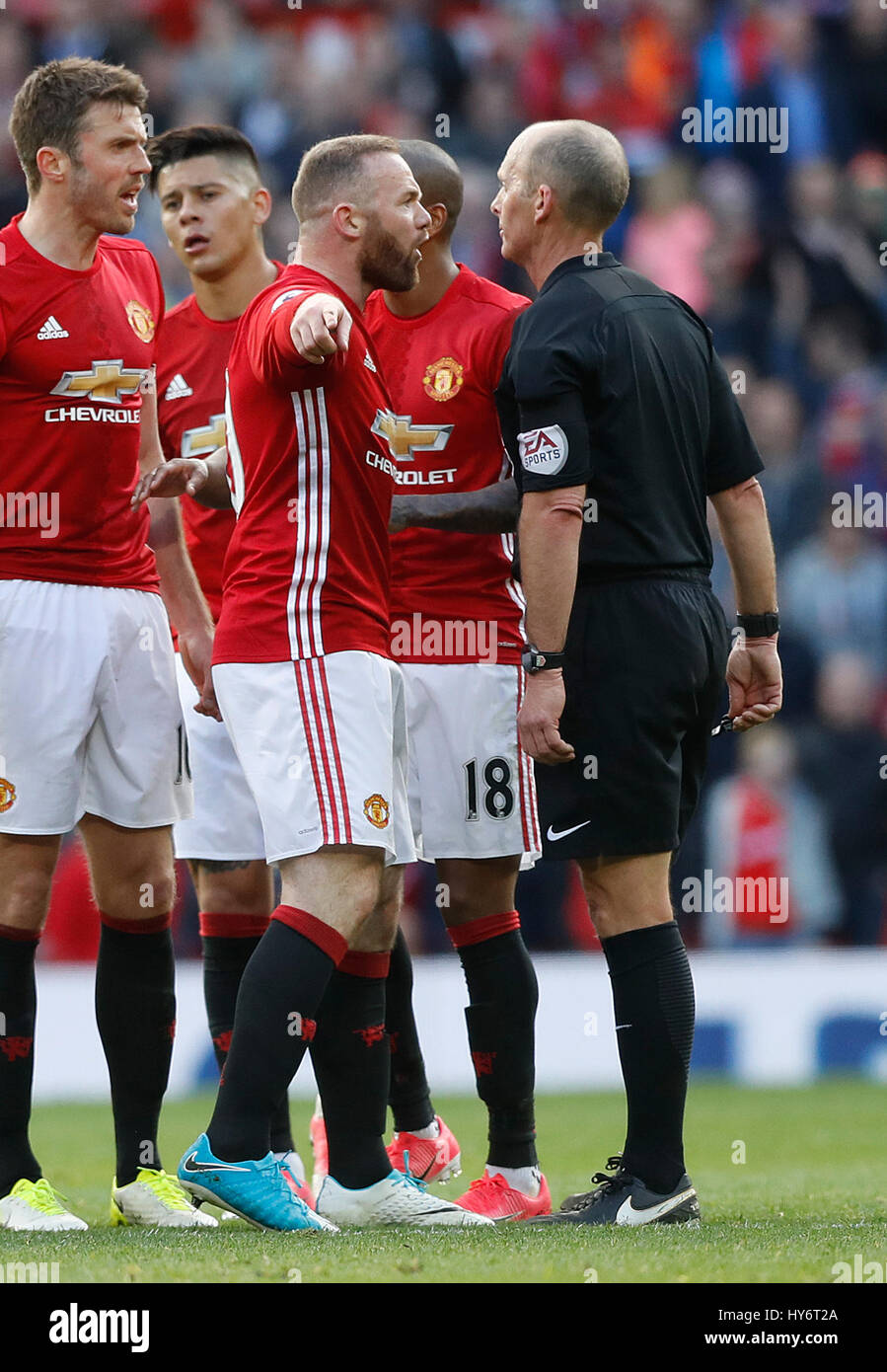 Manchester United's Wayne Rooney exchanges words with referee Mike Dean