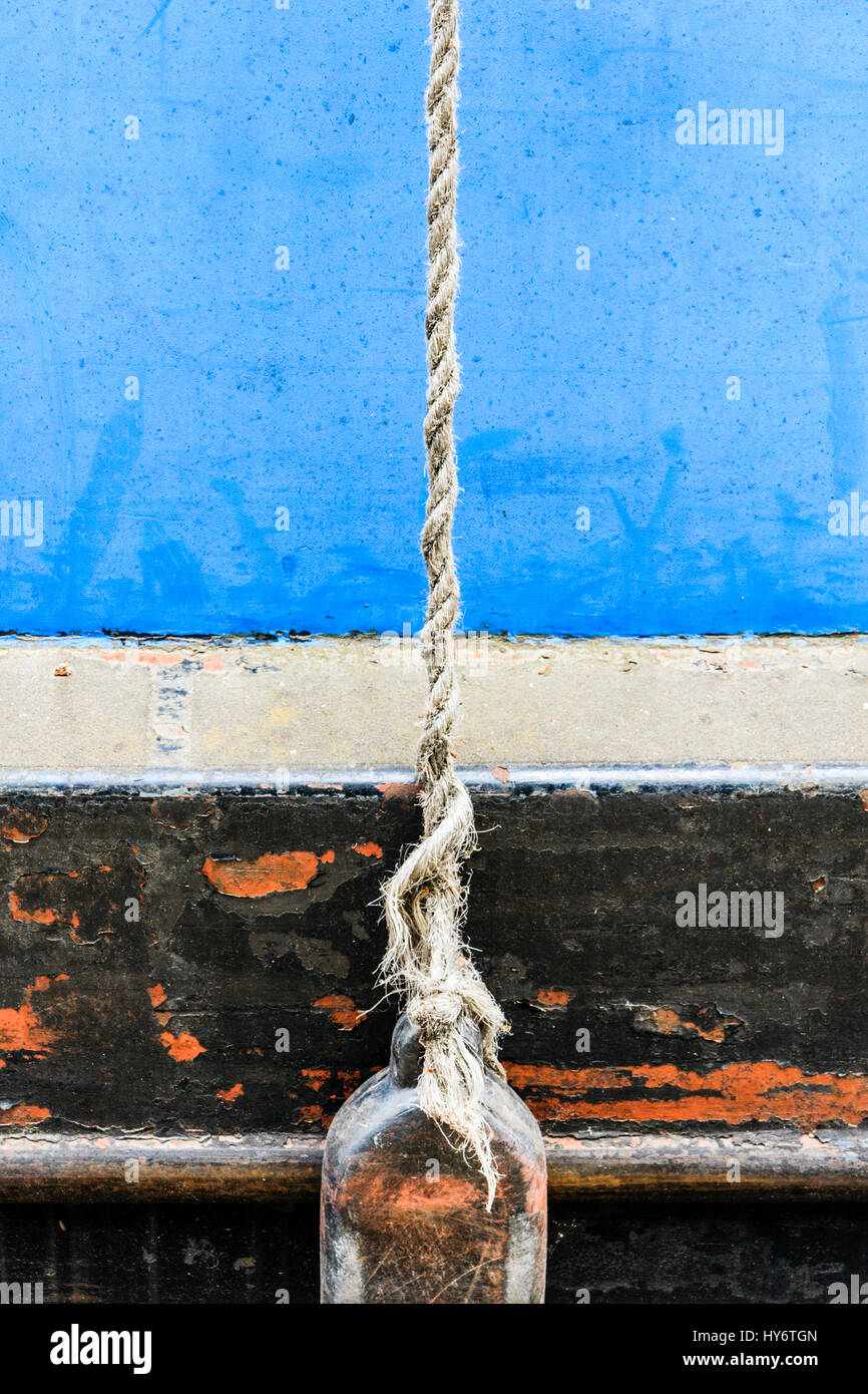 A plastic fender hanging by a rope on the side of a narrowboat moored on Regent's Canal, King's Cross, London, UK Stock Photo