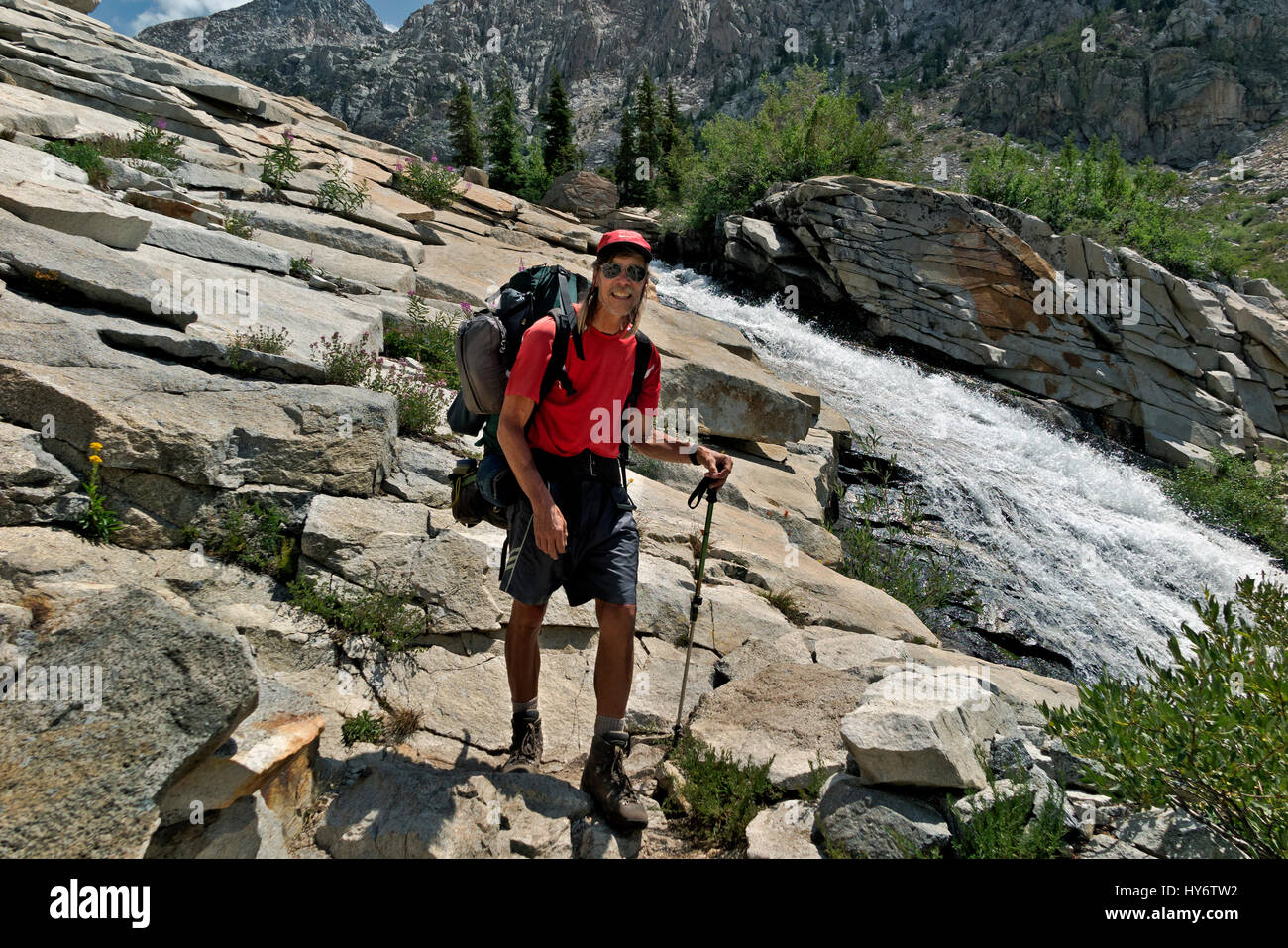 CA03157-00...CALIFORNIA - Hiker on the combined PCT/JMT near a cascade on Palisade Creek in the Sequoia and Kings Canyon Wilderness. Stock Photo
