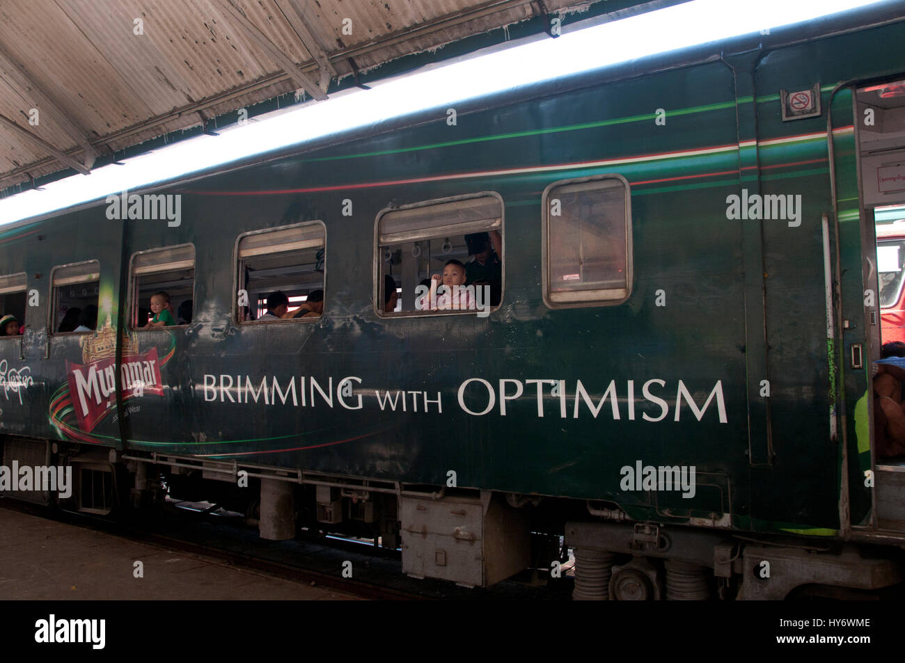 Myanmar (Burma). Yangon. Circular train with a carriage painted with an advert for beer and the word 'optimism'. Stock Photo
