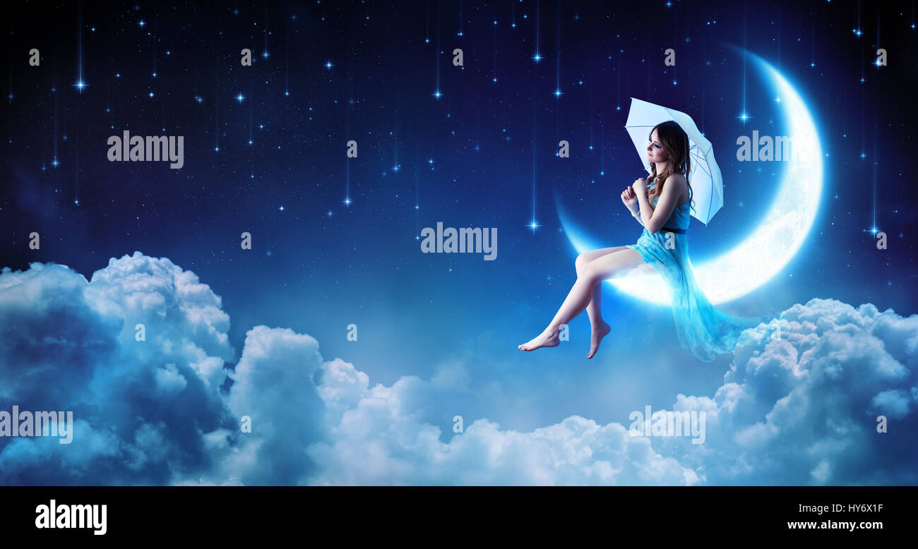 Dreaming In The Fantasy Night - Fashion Girl Sitting On Moon Stock Photo