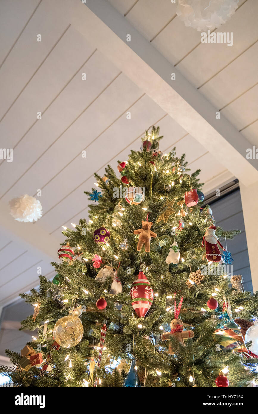 A lit and decorated Christmas tree inside a home Stock Photo