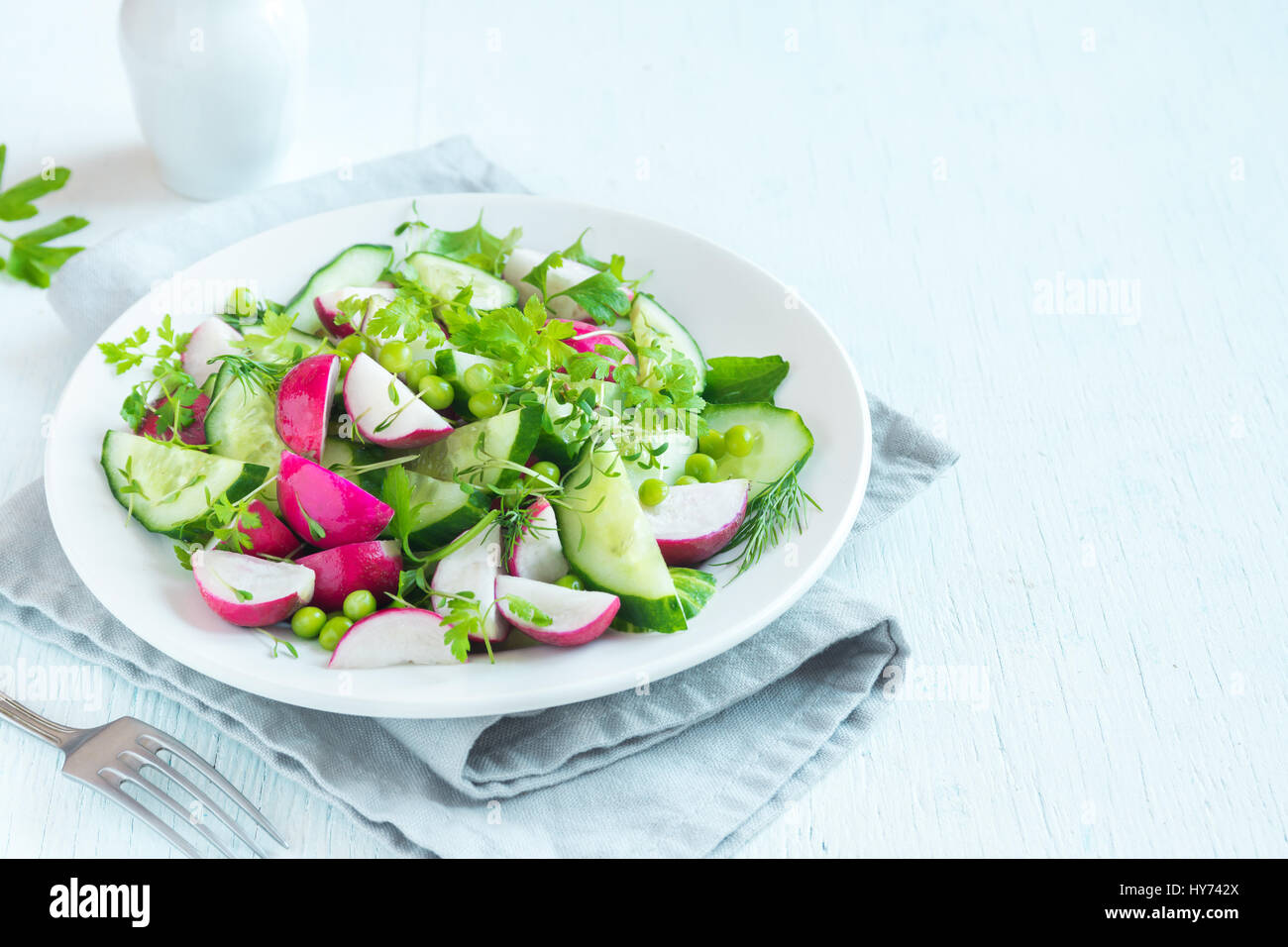 Healthy spring vegetables salad with radish, cucumber, green peas and sprouts, diet, vegetarian, vegan, organic, green food, spring detox snack. Stock Photo