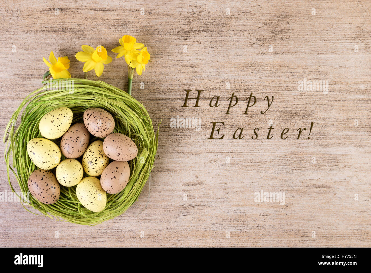 Easter background Happy Easter. Retro decoration green Easter nest with daffodils on rustic light brown background Stock Photo