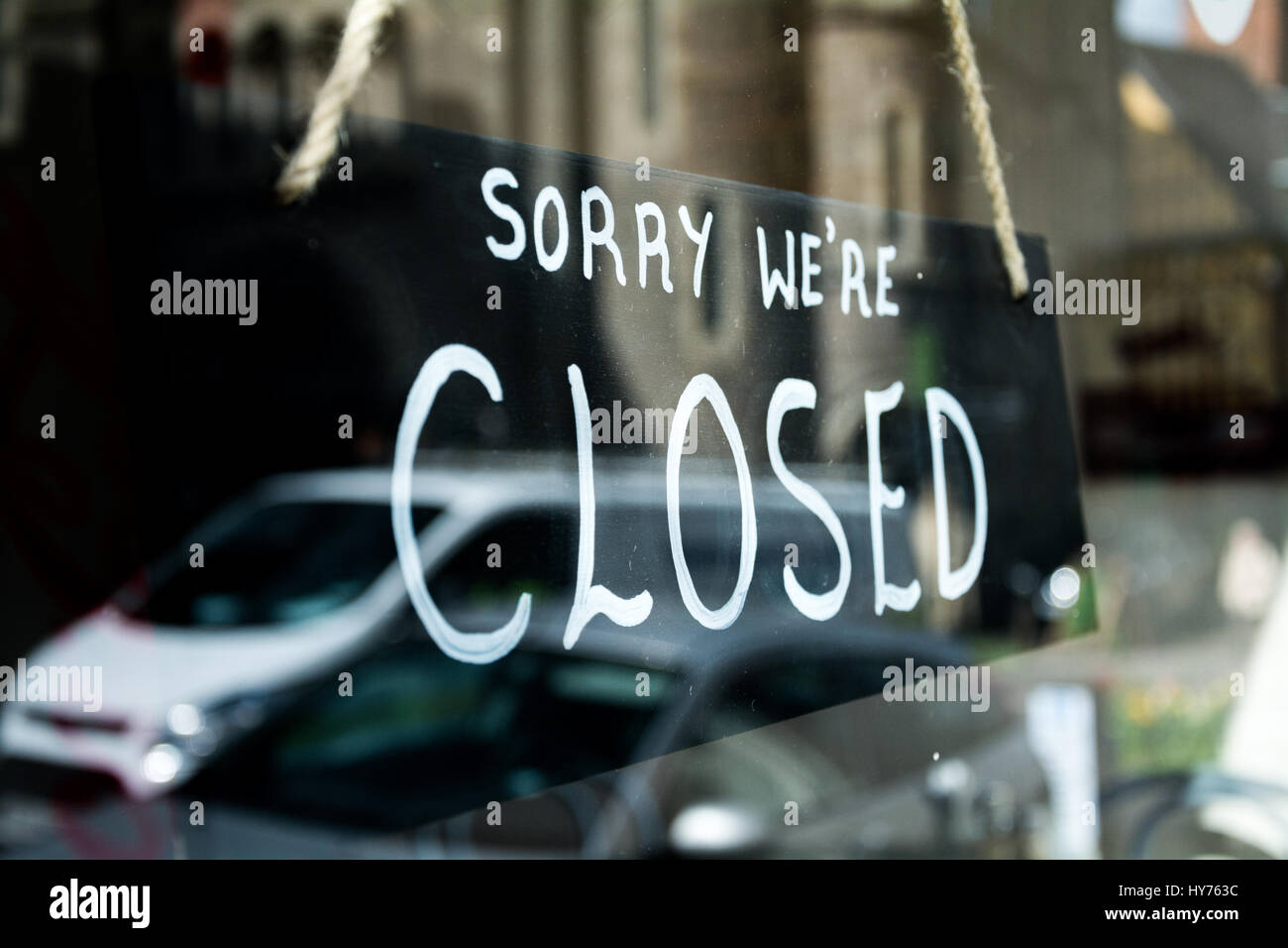 - Sorry we're closed -  sign in shop window. Small business in the UK. Stock Photo
