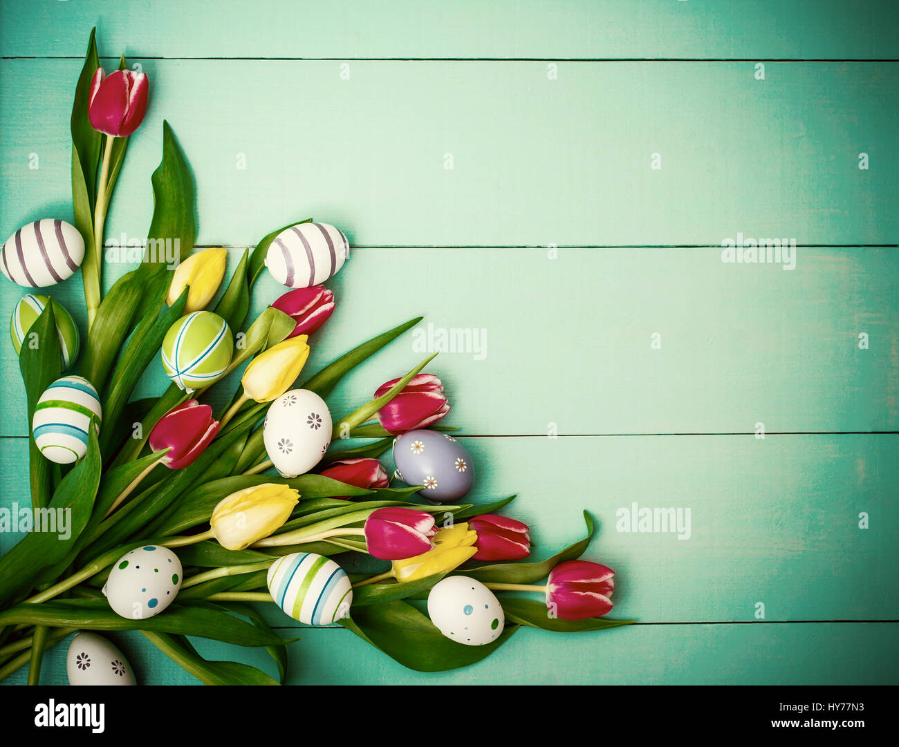 Red and yellow tulips with colorful Easter eggs, top view Stock Photo ...