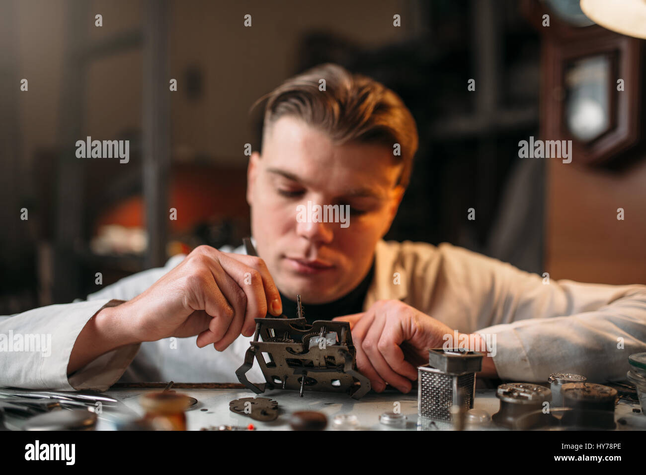 Watchmaker with loupe repair clockwork mechanism. Clock maker at work