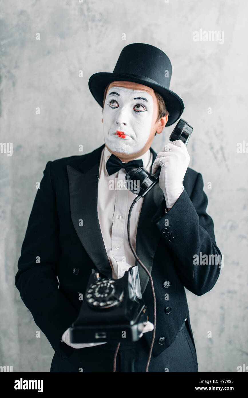 Pantomime theater actor with makeup mask performing with retro telephone.  Comedy artist in suit, gloves and hat Stock Photo - Alamy