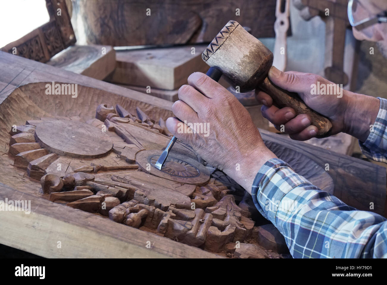 Wood carving. Carver with chisel and hammer. A skillful craftsman