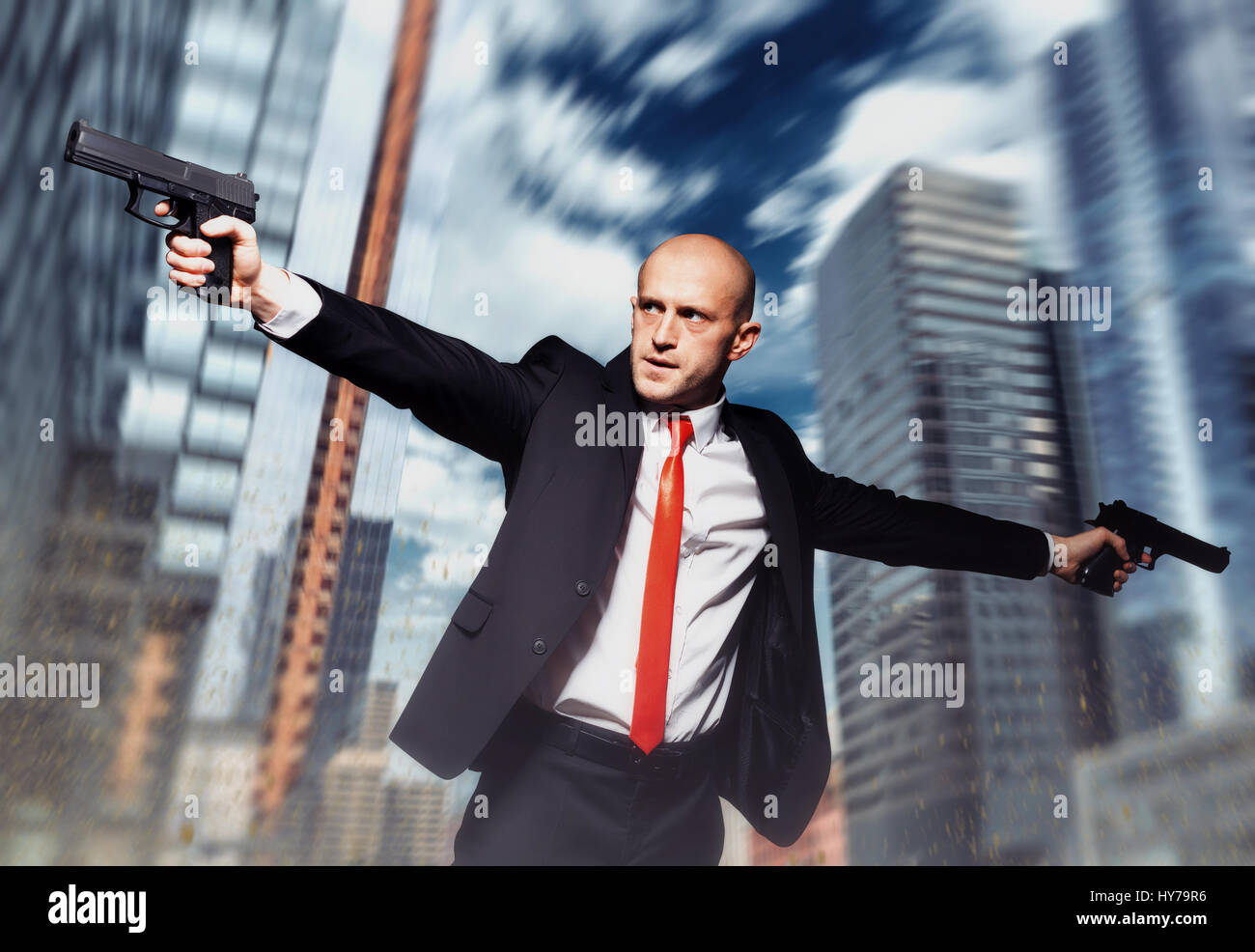 Serious contract killer shooting action wallpaper, background or poster.  Bald assassin in red tie fires a pistols with two hands on city street. Pro  Stock Photo - Alamy