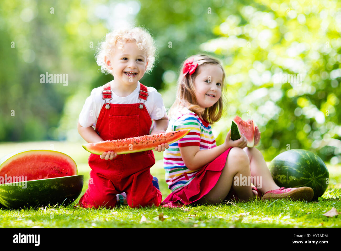 Child eating watermelon in the garden. Kids eat fruit outdoors. Healthy