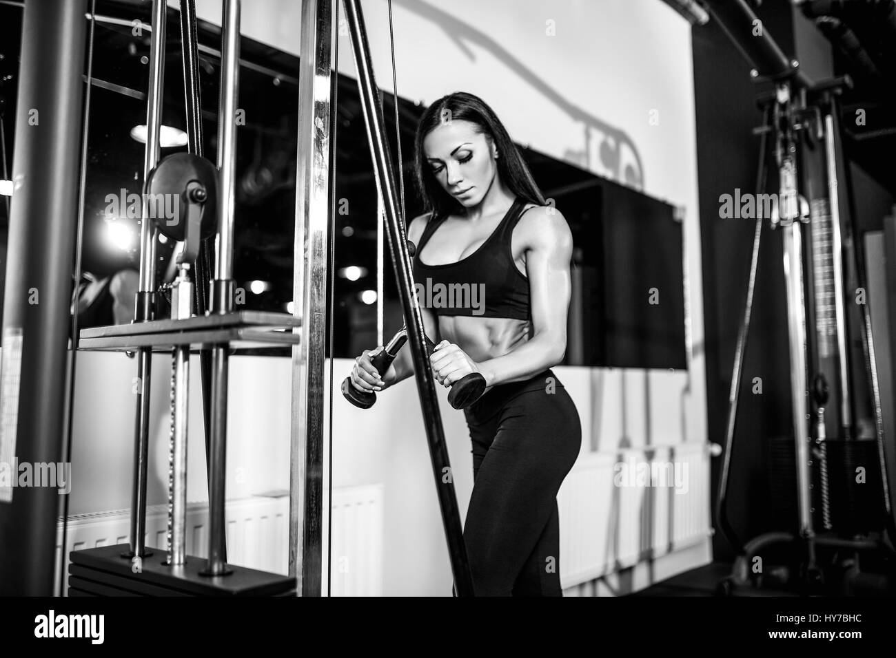 woman flexing muscles on cable machine in gym. exercise on triceps Stock Photo Alamy
