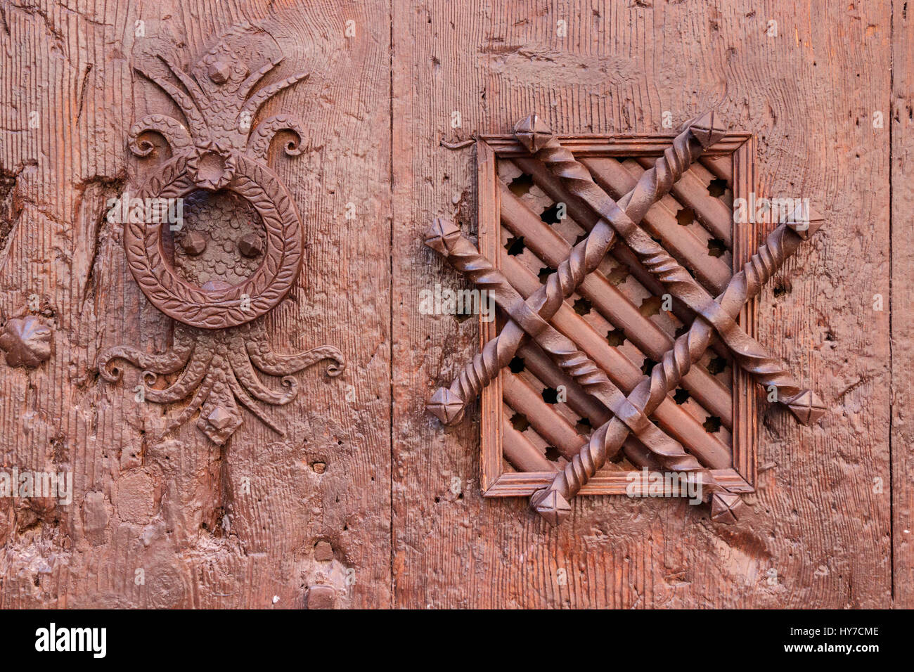 Ornamented knocker and spyhole in an old wooden door. Albarracin, Teurel, Spain. Stock Photo