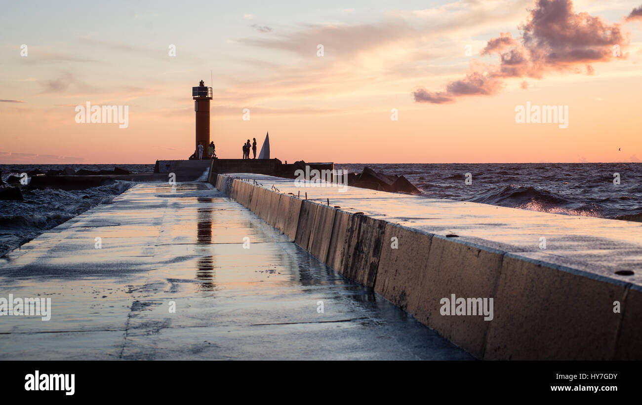 lighthouse with rusty metal rails near sea port and silhouettes Stock ...