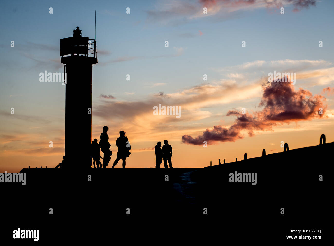 lighthouse with rusty metal rails near sea port and silhouettes Stock ...