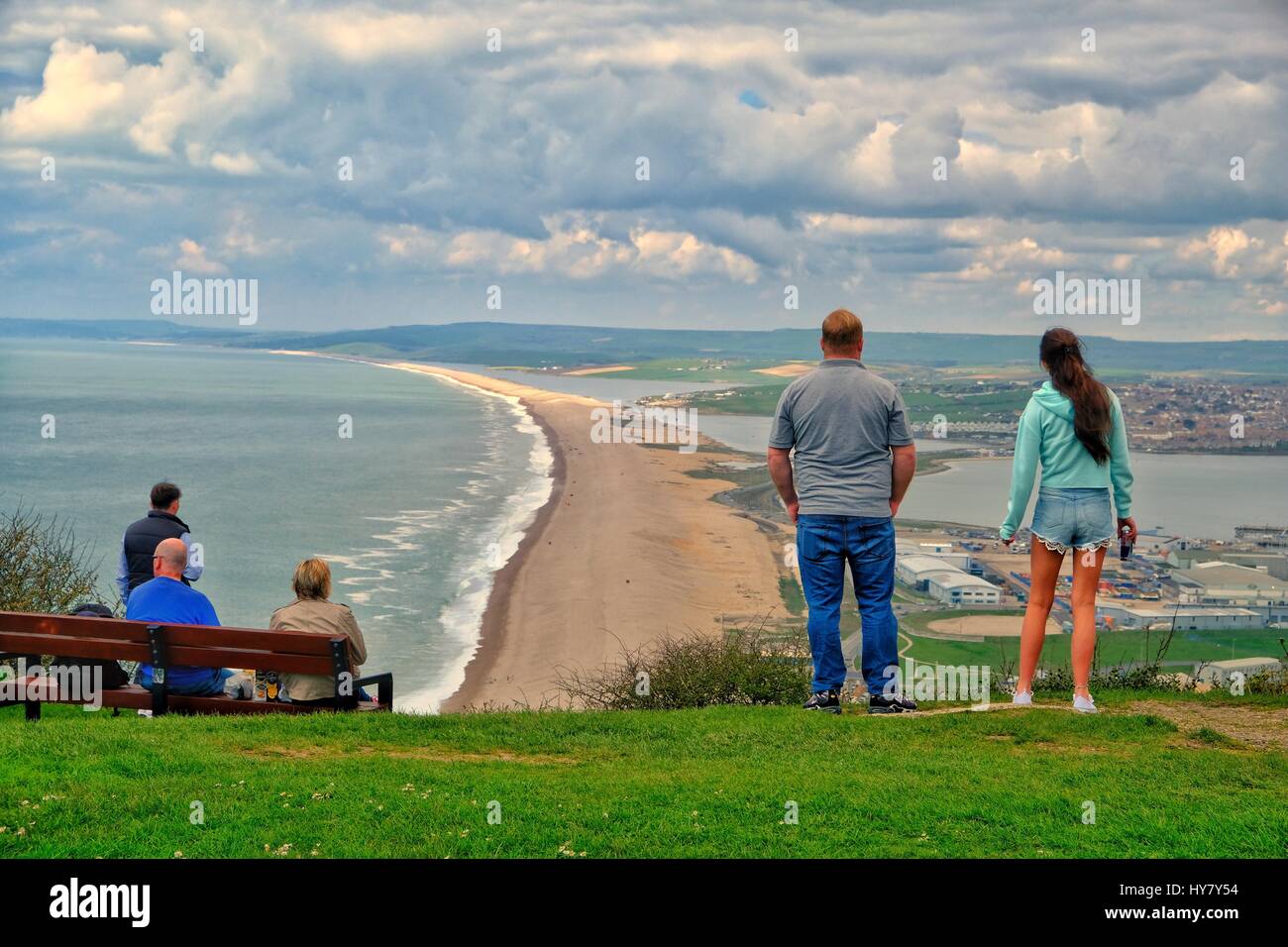 Portland Heights, Dorset, UK. 2 April 2017.  A young couple look down on Chesil Beach from Portland Heights as the Dorset Coast enjoys another warm day Credit: Tom Corban/Alamy Live News Stock Photo
