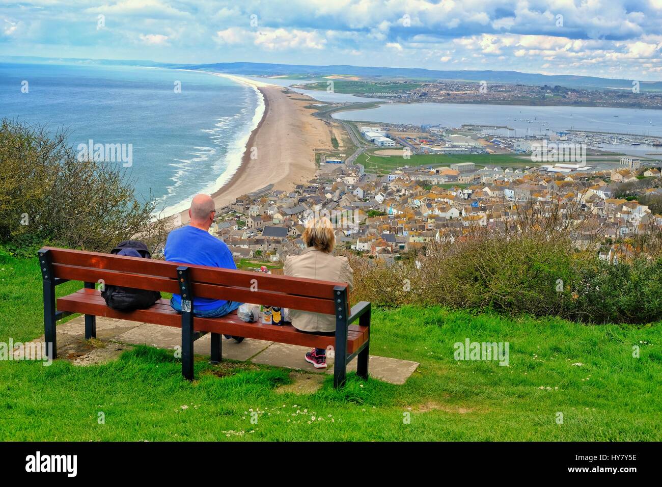 Portland Heights, Dorset, UK. 2 April 2017.  A young couple look down on Chesil Beach from Portland Heights as the Dorset Coast enjoys another warm day Credit: Tom Corban/Alamy Live News Stock Photo