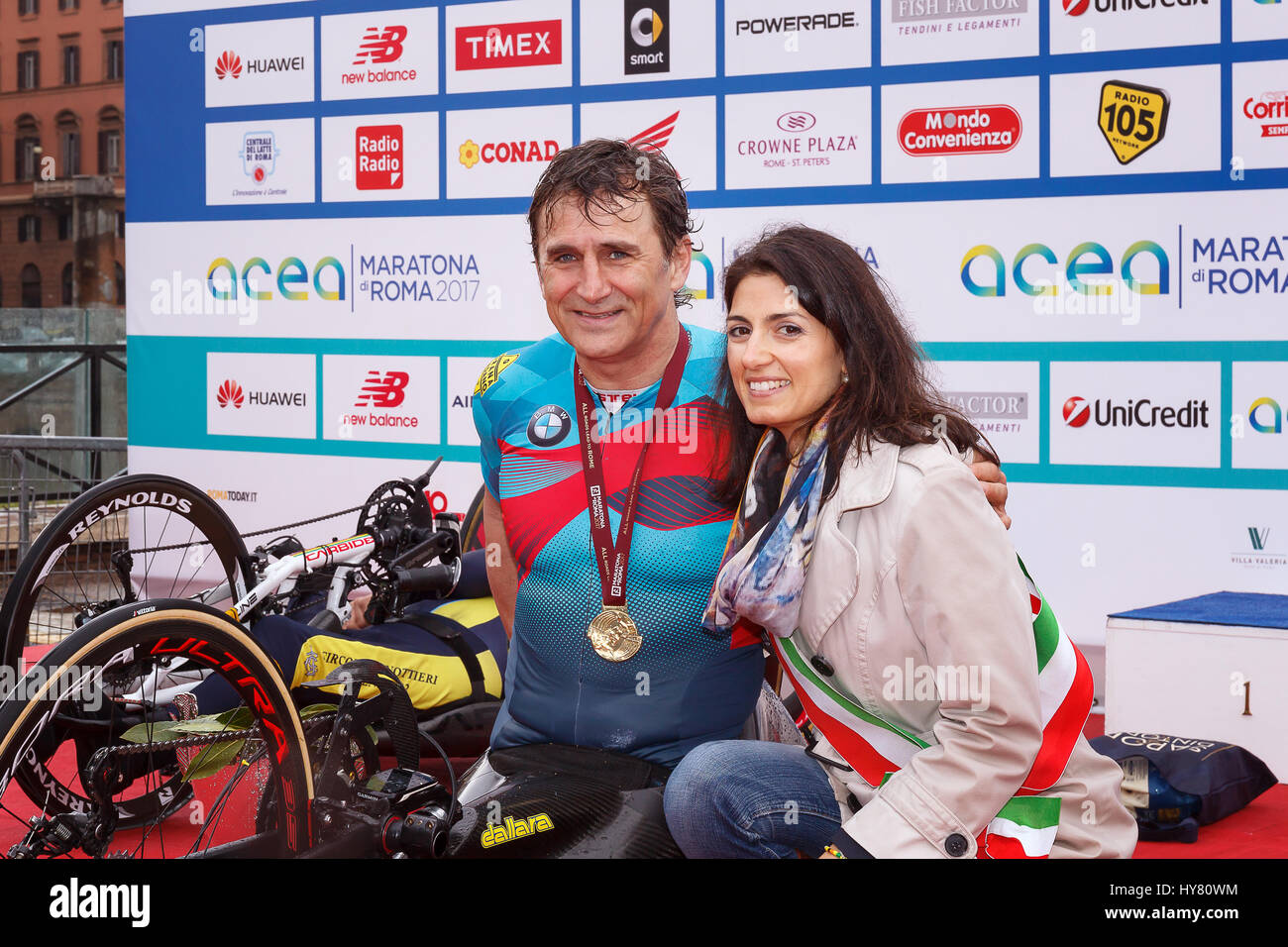 Rome, Italy. 02nd Apr, 2017. Alex Zanardi is the winner of the hand bike race of 23rd Rome Marathon. On stage together with the mayor Virginia Raggi during the award ceremony. Credit: Polifoto/Alamy Live News Stock Photo