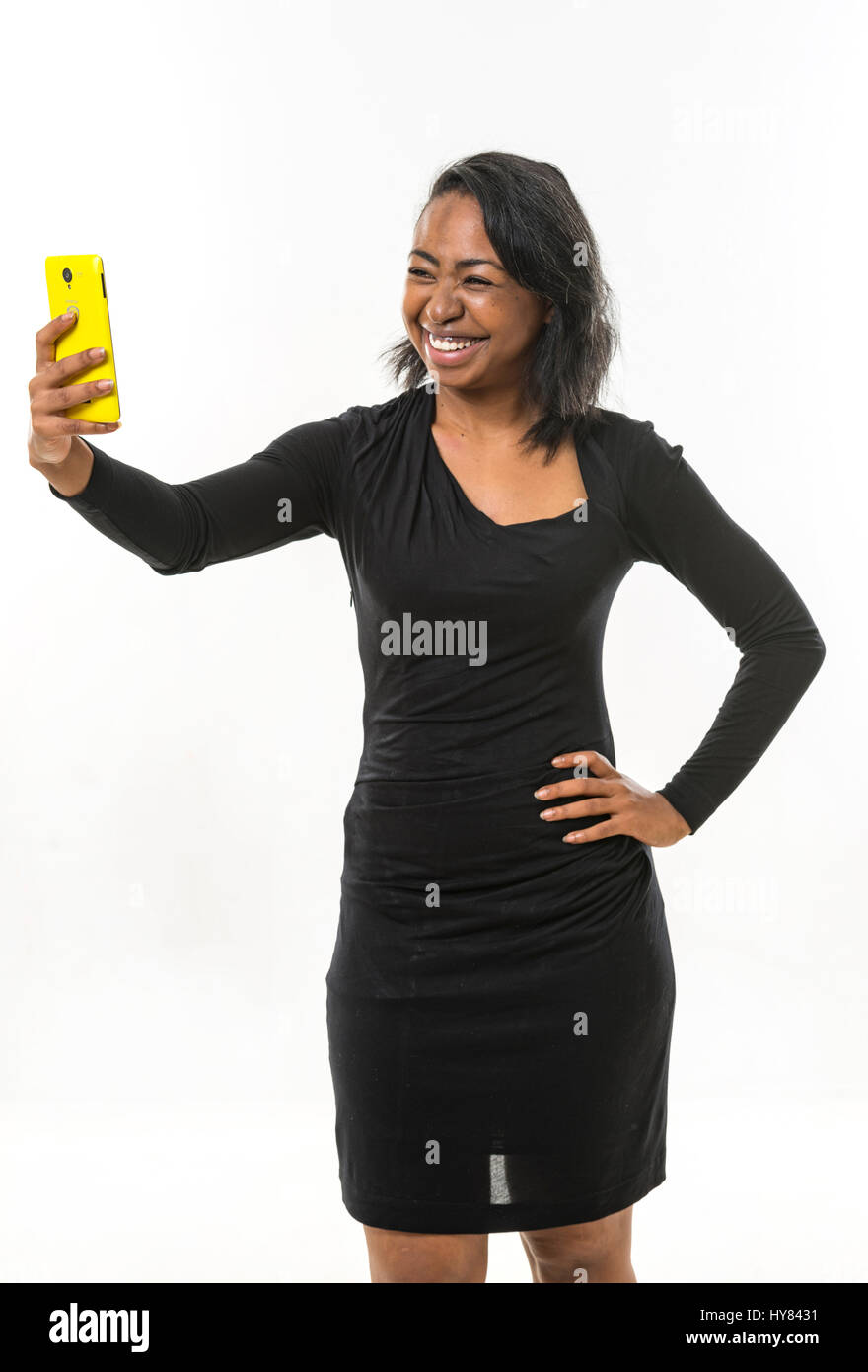 An African woman uses a mobile device in a studio environment. Stock Photo