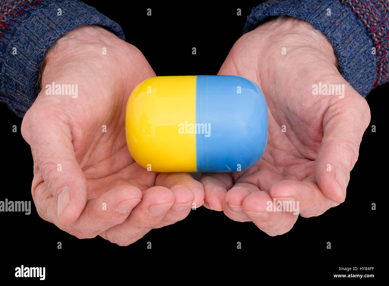 Bitter pill to swallow. Concept, metaphor. Older man's hands offer pill