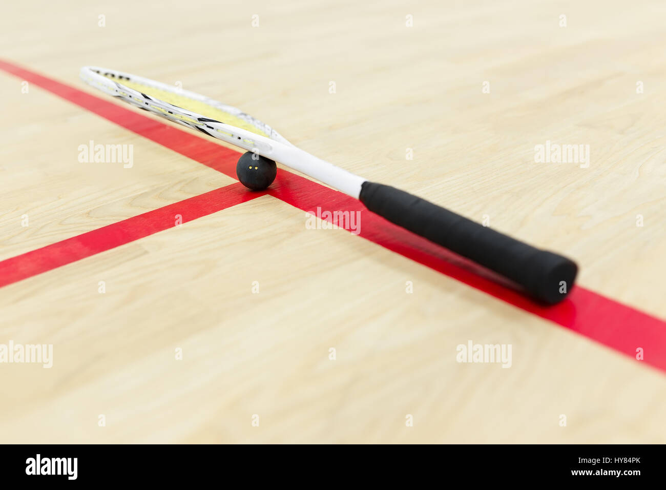squash racket and ball on the wooden floor. Racquetball equipment for