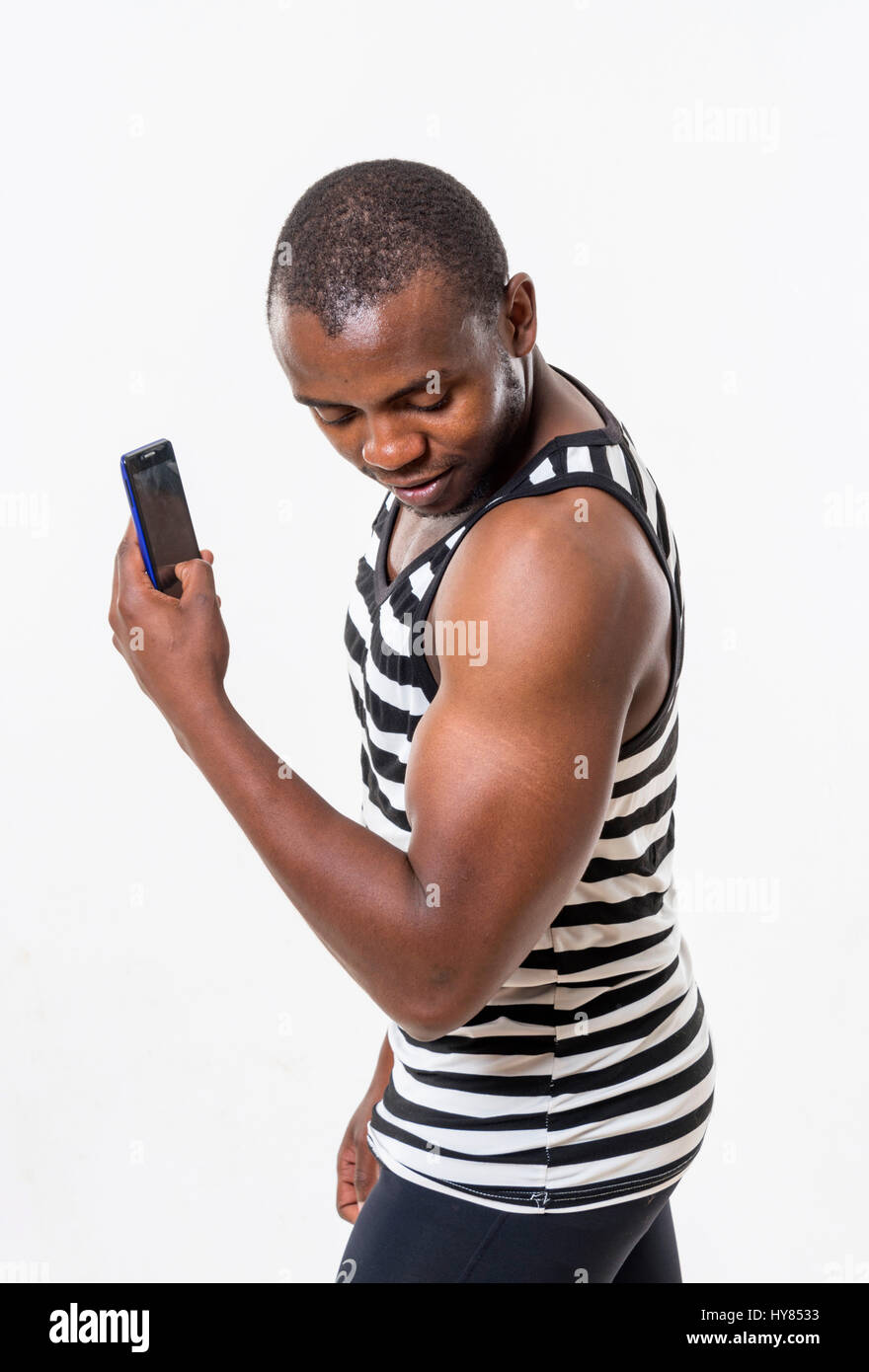 An African man uses a cellphone in a studio environment. Stock Photo